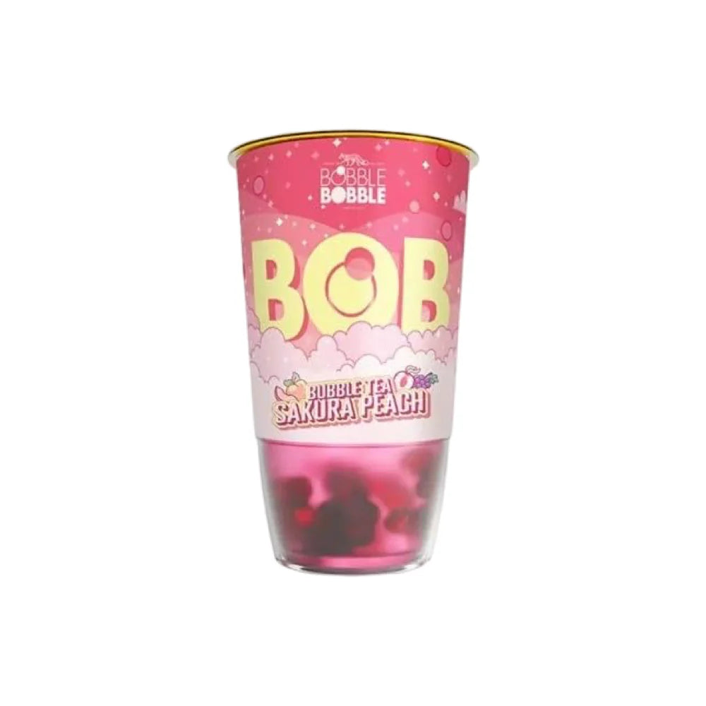 Le MIDI MINUIT « Bubble Tea Bob Sakura Peach » (360 ml) présente des perles de boba roses à travers sa base transparente dans une tasse rose étiquetée « BOBBLE BOBBLE », décorée de nuages et de graphismes pour une sensation fantaisiste de fleur de cerisier.